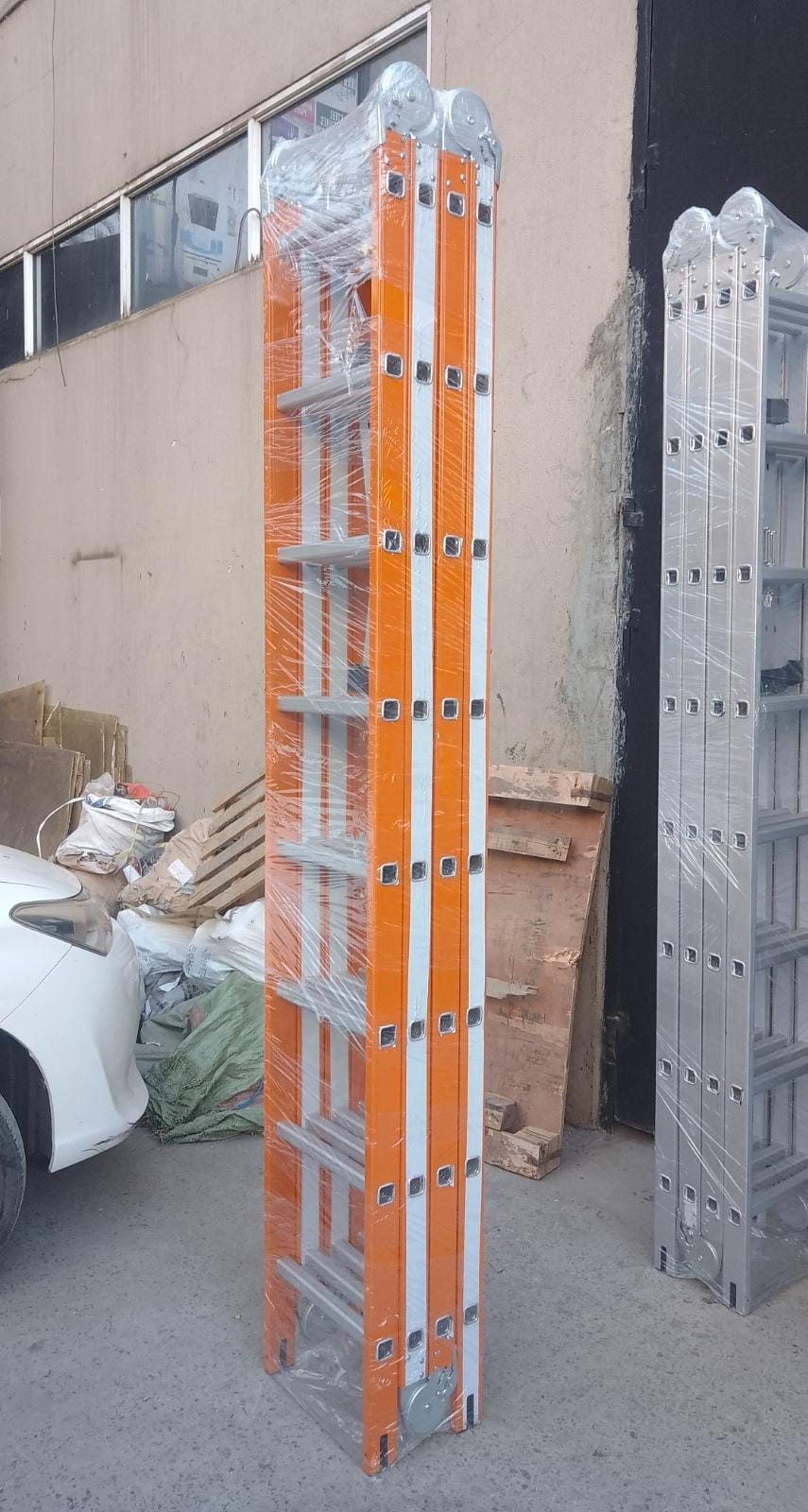 Heavy duty 32ft 9.5m multipurpose aluminum folding ladder 4x8 steps in orange color standing extended in Kenya.